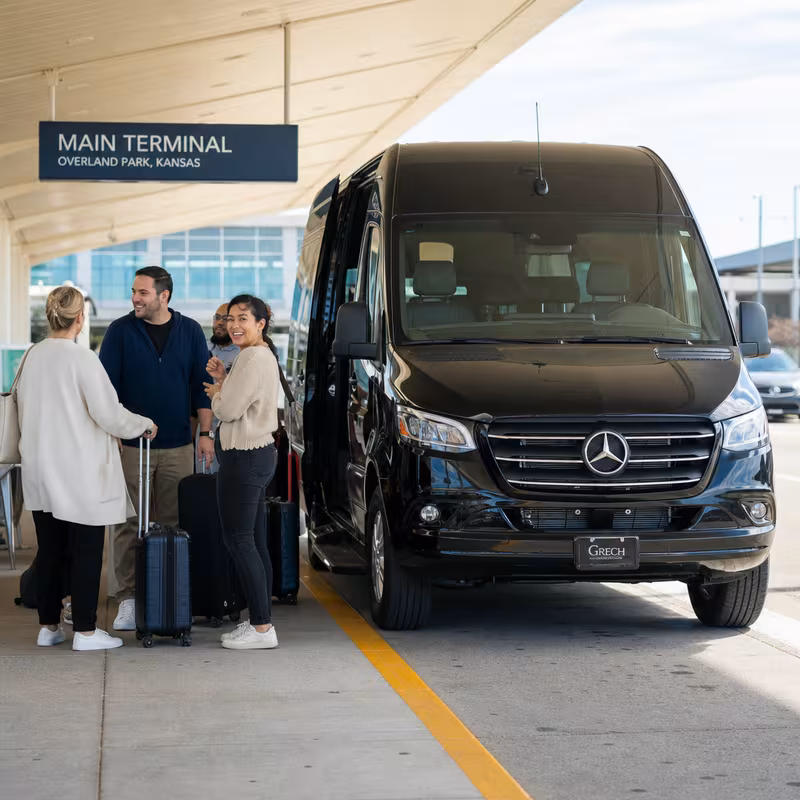 Group boarding a white charter bus for Airport Transportation transportation in Overland Park
