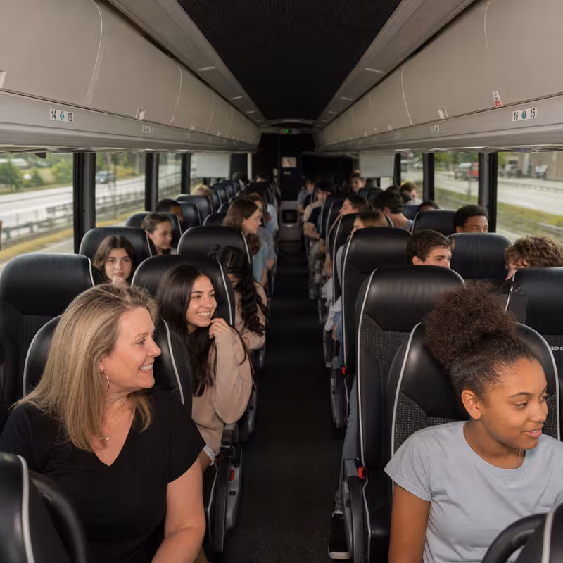 Group boarding a white charter bus for School Transportation transportation in Overland Park