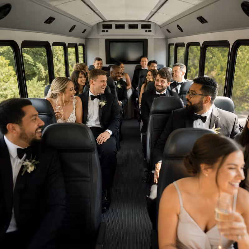 Group boarding a white charter bus for Wedding Transportation transportation in Overland Park